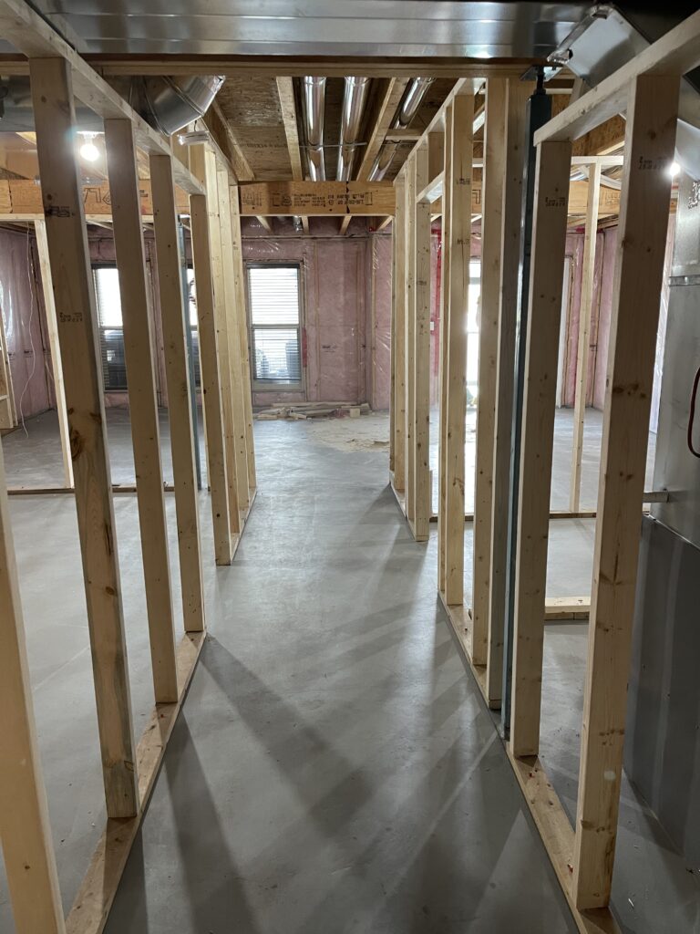 Interior wood stud framing in a residential hallway under construction