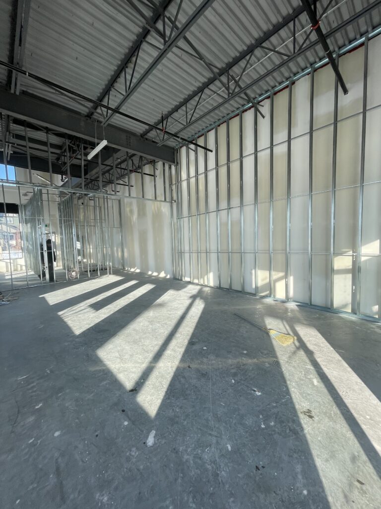 Drywall-ready commercial interior in Edmonton, AB with metal stud framing and natural light