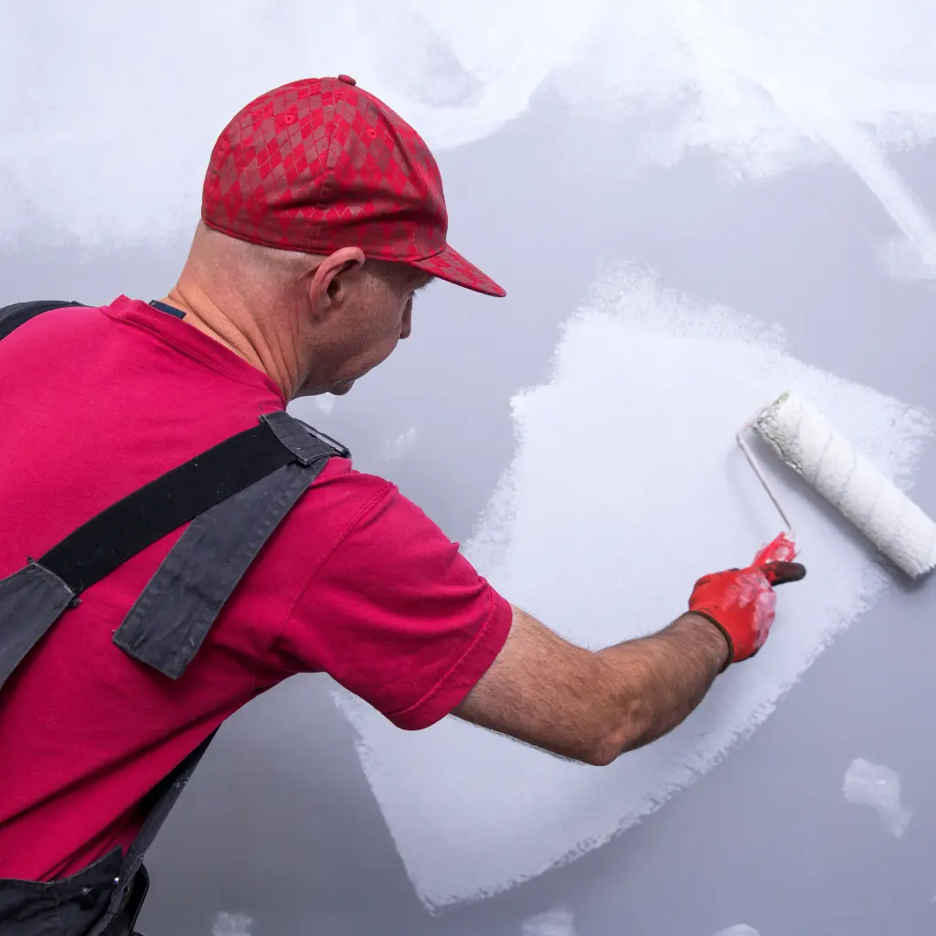 Professional painter painting a wall white with a paint roller