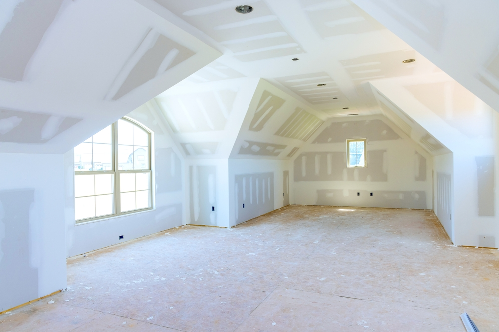 Large unfinished room with completed drywall installation
