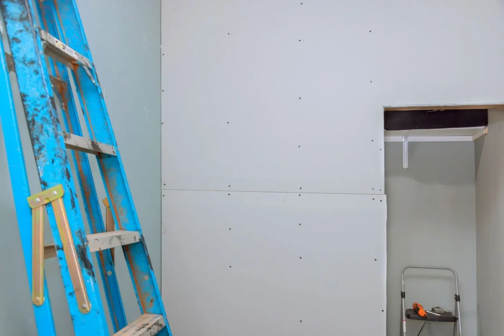 Recurring drywall nail pop damage on a wall and ceiling in an Edmonton home